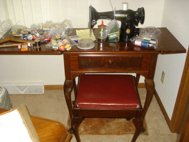 1951 Singer Electric sewing machine with bench, attachments, and storage.