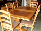 Large Hacienda style trestle dining table with leaf. Has six matching chairs with a faux leather upholstery.