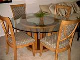 Beveled glass top dining table with four chairs.