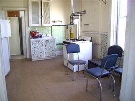 Upstairs kitchen with sink, stove, chairs.