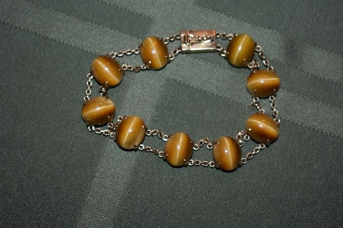 Strikingly Beautiful 18kt Gold Tiger Eye Bracelet! - One ladies 18kt gold double row cable style bracelet mounting weighing approximately 12.8 dwt and is set with nine oval cabochon cut tiger eye stones measuring approximately 12mm in length by approximately 10mm in width. Bracelet measures approximately 7 1/2" in length.