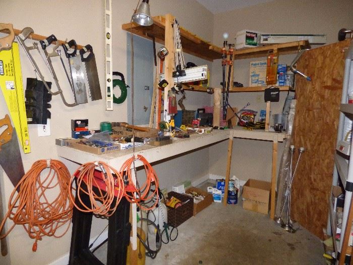 Small shop area in garage with hand tools, power tools, yard tools, etc