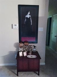 Poster of Portrait of Madame X by John Singer Sargent and end table with decorative items