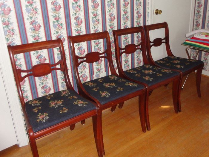 Set of four chairs with matching needlepoint upholstery.