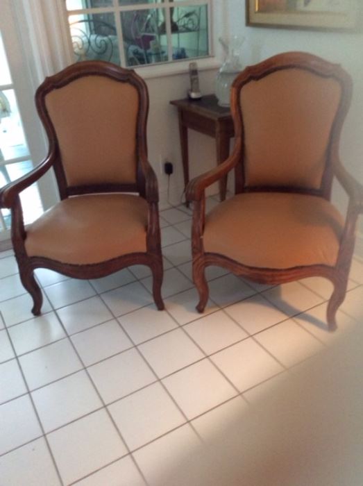 Pair of restoration armchairs, walnut frames, nail heads, and tan leatherette. 
