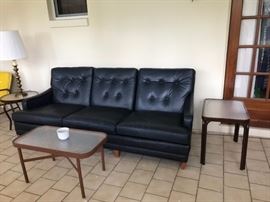 One of two Navy leather sofas show with two side tables and a coffee table