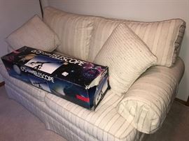 Upholstered striped neutral colored love seat 