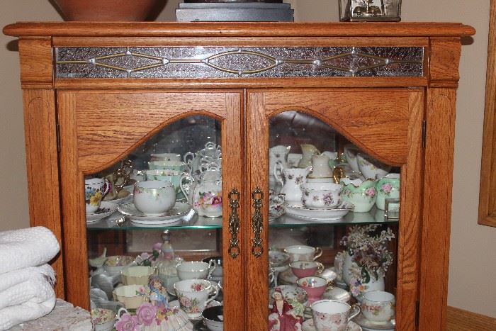 oak china cabinet filled with china