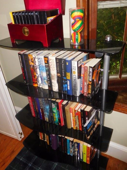 Pair of black glass and metal bookshelves and huge collection of popular titles and young adult novels