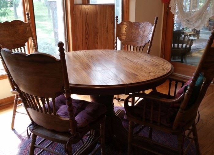 Oak pedestal table and pressed back chairs