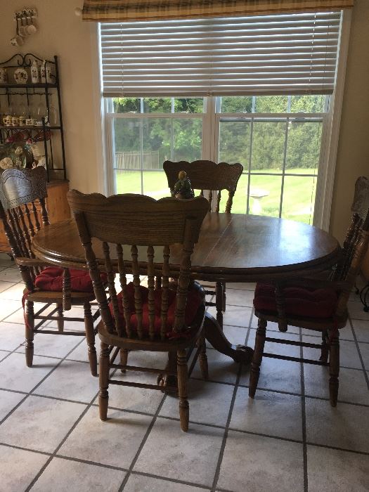 Hardwood kitchen table with claw foot base and four chairs.  Remove extender for round table.  