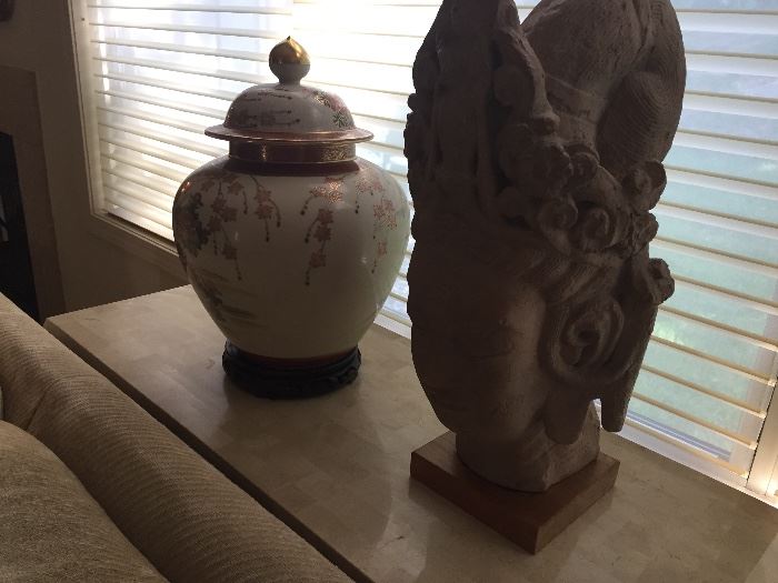 ceramic urn and stone sculpture on top of fossil stone sofa table or entry way table