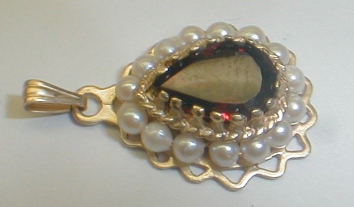 14k yellow gold pendant with pear cut garnet surrounded by small pearls. 3/4" tall. 3.2 grams