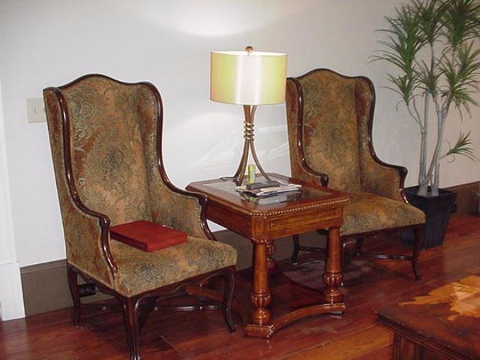 High back upholstered arm chairs with cabriole legs, occasional table with glass top covering a carved wood grid