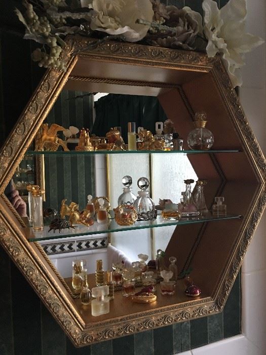 Gold curio glass shelf cabinet with Este Lauder "collectores" perfume bottle collection 
