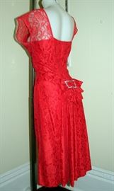 Vintage 1950s party dress.  Allover red lace with a satin lining.  Large rhinestone bow buckle on back.