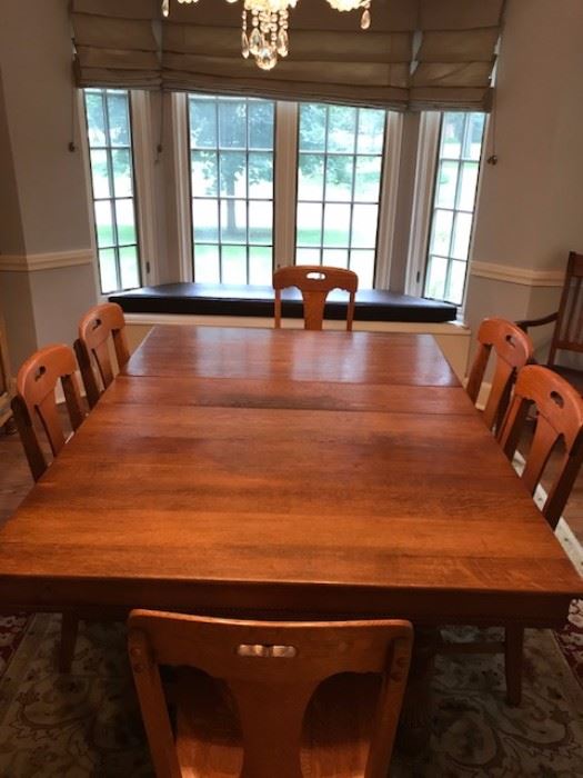Beautiful solid oak table with three leaves, that comfortably seats 10 people and can be extended to accomodate 20+ people.  6 matching chairs + 2 Captain chairs... 