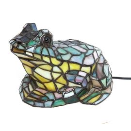 Stained Glass Frog Lamp: A stained glass frog lamp. This forgot shaped lamp is made of metal with stained glass panels in colors of green, purple, yellow, pink, and red. The piece is unmarked.
