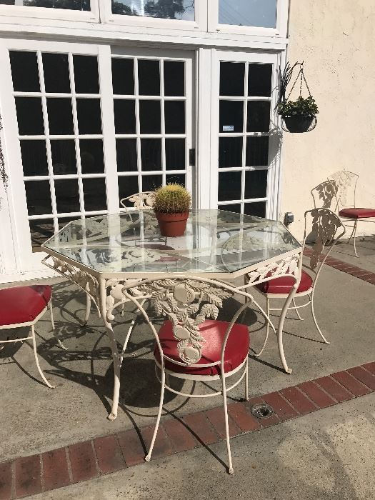 Wrought iron patio set with 6 chairs. Features an apple motif . Red vinyl seats. Very cute!