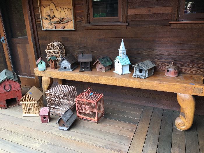 ASSORTED BIRD HOUSES & CAGES ON WOOD CARVED TABLE.