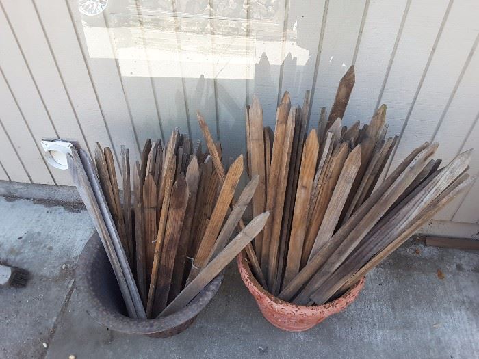 Wood Stakes for gardening projects, medium size containers, one is plastic, the other is pottery.
