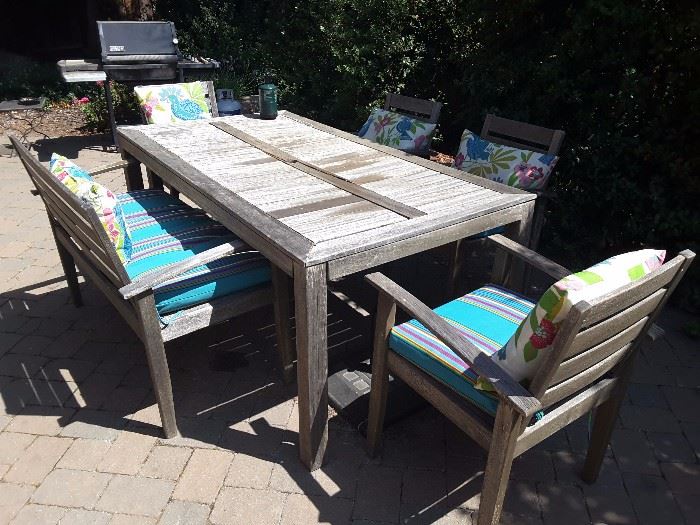 View of picnic table. 4 chairs and 1 on longer (2 seater) bench, new cushions blue stripes. Please note the table has a split in the middle from a recent wind storm, needs to be refinished, fixed up. From World Market.