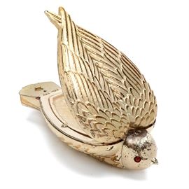 Rare Salvador Dali "Bird-in-Hand" Compact by Elgin American: A rare Bird-in-Hand compact designed by famed Spanish Surrealist Salvador Dali for Elgin American. This hard to find compact features a streamlined bird form that fits nicely in the palm of a hand, having a silver plated finish with gold tone accents and red enameled eyes. The head piece pulls out as a lipstick holder, the wings open upward to an inverted heart-shaped mirror with powder compartment below, and a pill compartment is hidden in the tail feathers. The compact was designed by Salvador Dali in a 1950 collaboration with Elgin executives, being first manufactured in 1951 by The Illinois Watchcase Company under the Elgin American label. Marked “Dali” to the head and “Elgin American Made in USA Pat Pend.” to the inside powder cover.