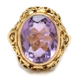 14K Yellow Gold Amethyst Ring: A 14K yellow gold amethyst ring. This ring features a bezel set 6.82 cts faceted amethyst stone in a fancy twisted wirework setting.