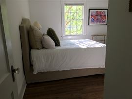 A queen-sized Parsons bed in Belgian linen upholstery by Restoration Hardware. Originally retail $1650, plus it comes with frame and boxspring. Bedding is not included. Entire set will be $450.