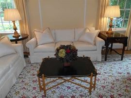 Living Room:  A two-piece BAKER Country French leather tray with faux bamboo stretcher coffee table (28" x 40" x 18" tall) is in front of a pair of exquisite ivory color 7' long three-cushion down-filled sofas (two matching toss pillows are included with each sofa).    