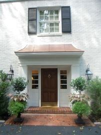 Front Door: The entrance to the house which shows two large heavy black cast iron urns with live plants (a closer photo coming up).  They are sold as a pair.  Entry will be at the side door to the RIGHT of this entry as we did not want to disturb the beautifully staged foyer with the check-out stations.  