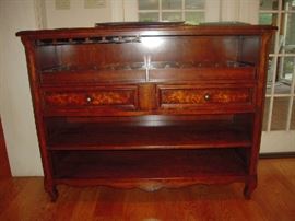 Sun Room:  This item was placed in the first floor sun room to make it easier for you to move upon purchase.  It is a quality cabinet made by WOODBRIDGE FURNITURE COMPANY and measures 56" wide x 20" deep x 43" tall.  There are open upper and lower shelves as well as two middle drawers.  The top shelf has two removable trays that hold wine bottles; to the left is an attached rack from which you can hang stemware.