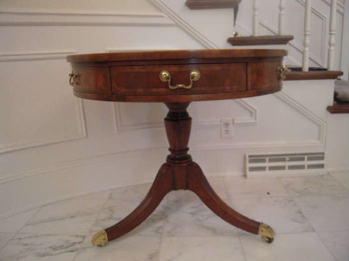 Foyer:  The classic mahogany 31" round Regency drum table has six drawers--but only two actually open as the other four are stationery. Notice the turned pedestal support and channeled legs with brass cap feet and casters.