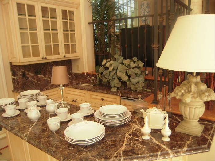 Sun Room-Atrium:   A collection of dishes by VISTA ALEGRE in the "Ruban Pink" pattern.  It is pink ribbons on a creamy white background.  Also shown are a couple of lamps, LENOX salt and pepper shakers, and miscellaneous other items.