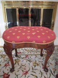Living Room:  A kidney-shape stool with French bees in a raspberry/gold fabric and gold braid trim is between the two wingback chairs.
