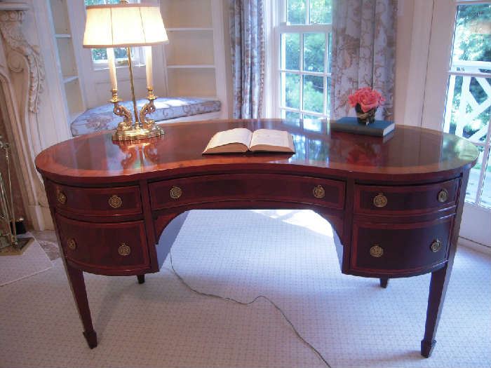 Master Bedroom-First Floor:  This magnificent mahogany Hekman Kidney Shape Writing Desk has a French  feel to it.  It features four drawers (including one file drawer on the right side) and fan medallion inlays.  It measures 60" wide x 26" deep x 30" tall.  The double dolphin brass lamp with HEWLITT-HITCHCOCK shade adds to the charm.
