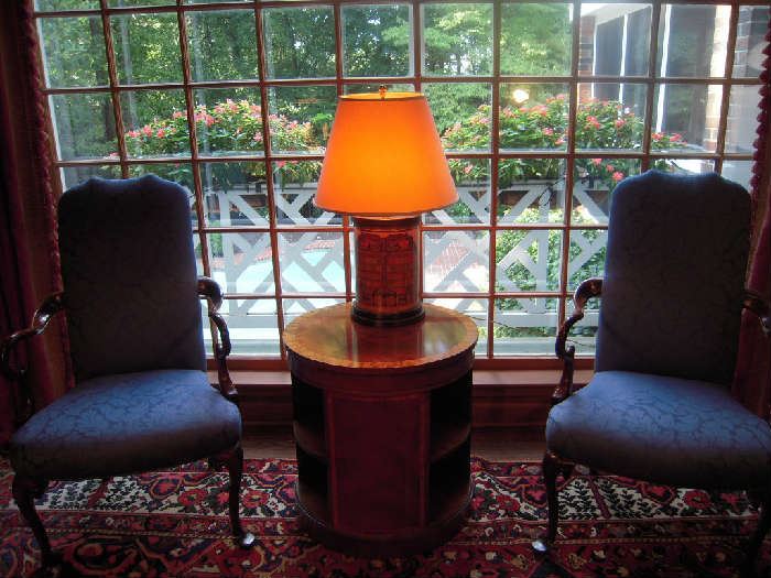 Library-First Floor:  Two blue design arm chairs flank a round BAKER book table and book-motif canister lamp.