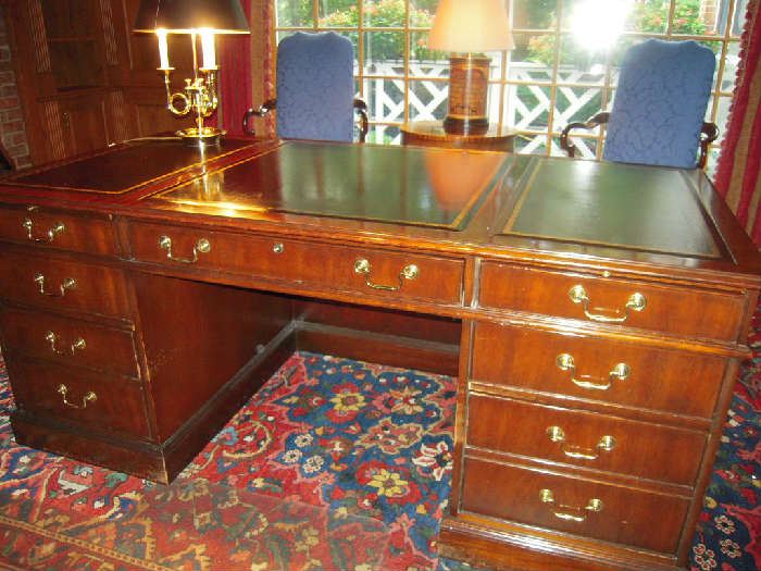 Library-First Floor:  The one-piece COUNCILL CRAFTSMEN mahogany desk with leather embossed top desk has three drawers on each side and a tummy drawer.  Above each pedestal stack of drawers is a pull out shelf.  