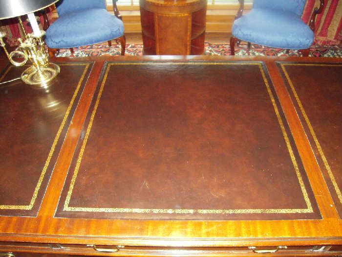 Library-First Floor:  This is a top view of the COUNCILL Craftsmen executive desk.  There are three leather embossed sections.  To the left is a brass BALDWIN bugle lamp with black shade. 