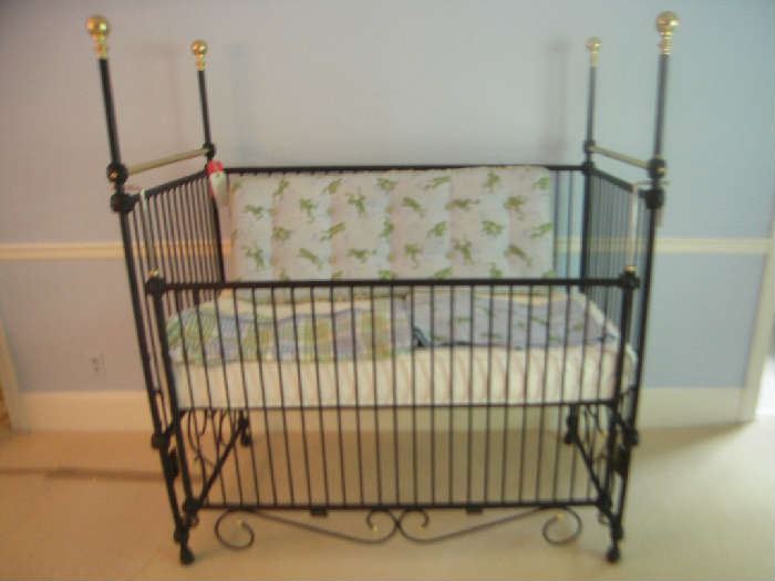 Bedroom #3-Upstairs:  This is an elegant black iron baby crib.  We put it together so you know it's gotta be easy to take apart as we are not mechanical!  It measures 54" wide x 31" deep x 61" tall to the top of one of the four corner posts.  We believe the bed to be in line with today's crib standards as the rails are narrow enough that a Campbell's Soup can does NOT fit in between them.  Today's regulations state that the slats cannot be more than 2-3/8" apart.  Please double-check all other standards if you are indeed going to use this unique bed for a child and not your favorite pet.