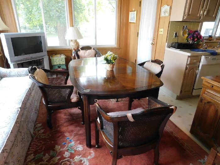 Another dining table set, with captain chairs and brass inserts on each corner