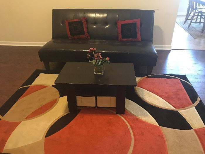Futon, small coffee table, and rug