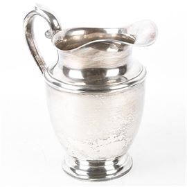 Sterling Silver Preisner Pitcher: A Sterling Silver Preisner water pitcher. The pitcher features a curved handle and round base. The pitcher is marked to the underside Preisner Sterling 125 with a total weight, inclusive of all materials, of 15.790 ozt.