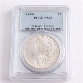 Graded MS-63 (By PCGS) 1883 O Silver Morgan Dollar: An encapsulated and graded MS-63 (By PCGS) 1883 O silver Morgan dollar. Designer: George T. Morgan. Mintage: 8,725,000. Metal content: 90% silver, 10% copper. Diameter: 38.1 mm. Weight: approximately 26.7 grams. Very good condition.