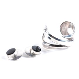 Sterling Silver Taxco Bracelet and Earrings: A sterling silver Taxco bracelet and earrings. Included is a cuff bracelet and a pair of disc shape clip-back earrings featuring round black cabochons. Both pieces are hallmarked “Taxco Sterling” and the total weight, inclusive of all materials, is 2.310 ozt.