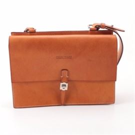 Dooney and Bourke Leather Shoulder Bag: A Dooney & Bourke tan leather shoulder briefcase. The briefcase features a smooth tanned leather on a structured case with a flap and turn lock closure. A matching shoulder strap and back zipper pocket complete the design along with branded embossing to the front, logo charms, and interior labeling.