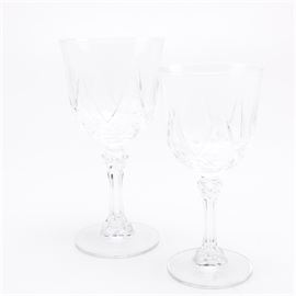 Crystal Wine Goblets: A pair of crystal wine goblets. This pair of crystal wine goblets features a cut bowl with multi-side stem and round base. No makers marks are noted.