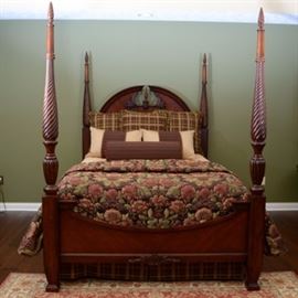 Queen Size Four Poster Bed: A beautiful cherry wood and wood veneer four poster queen size bed, features an arched headboard with carved wood appliqué to the pediment with finial center and rope detail. The four posts are richly detailed, with turned spires, topped acorn finials. The footboard features arched cut out, with carved appliquéd wood details. This bed includes a custom made nine piece bedding ensemble. Three large plaid square shams pillows, two queen size bed shams and a bolster pillow. Custom quilt made with high quality fabric with a large floral design, white fabric back and machine quilted construction. Coverlet is in a gold buttercream silky fabric with quilted circles and a coordinating dust ruffle. Mattress in NOT included.