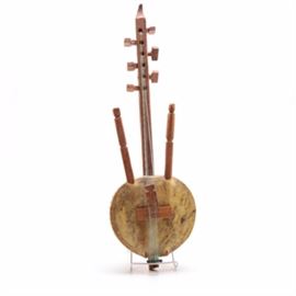 Decorative West African Inspired Kora: A decorative West African inspired kora. The instrument features a rounded gourd body with incised decorations to the back, as well as a marbled brown hide-like covering to the front. The piece includes a long carved wooden neck, flanked to either side with two carved wooden handles. It is strung with seven nylon strings.