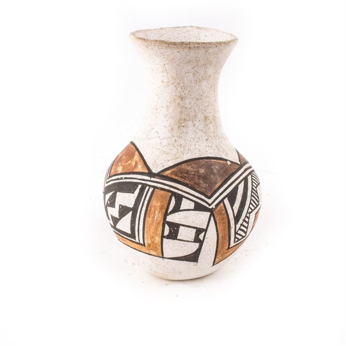 Acoma Pueblo Pottery Vase: An Acoma pueblo pottery vase. This vase is handcrafted of clay and features flared lip above a fluted neck and bulbous body. It is decorated with a two-tone brown and black traditional motif. The vase is marked on the underside “Acoma, N. Mexico”.
